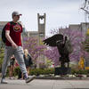 Temple Student walks past Bell Tower in Spring