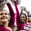 Four Temple Owls cheerleaders dancing at a football game